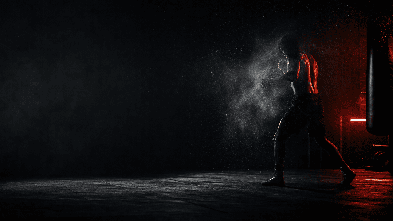 Fighter silhouette moving through chalk dust in a dark training room